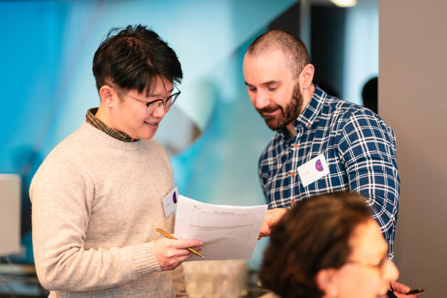 Two men discussing research checklist